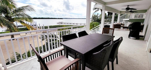 balcony with outdoor dining space, area for grilling, a water view, and ceiling fan