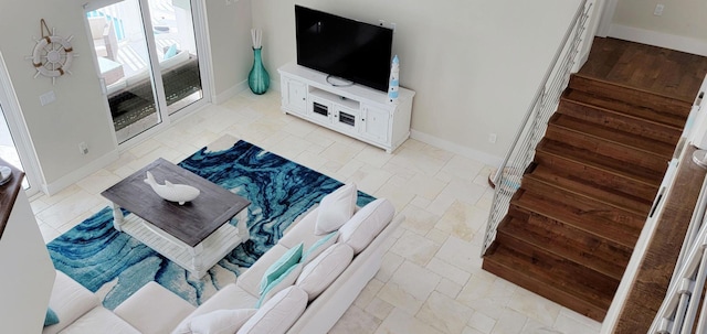living area with baseboards and stairs