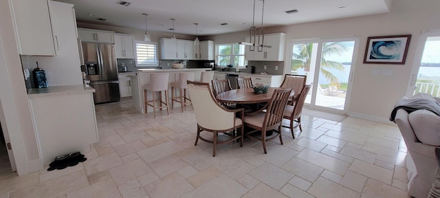 dining room with baseboards, visible vents, stone tile floors, and recessed lighting