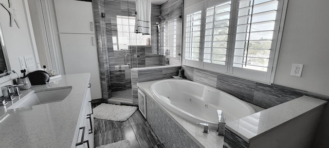 bathroom featuring vanity, a tub with jets, and a shower stall