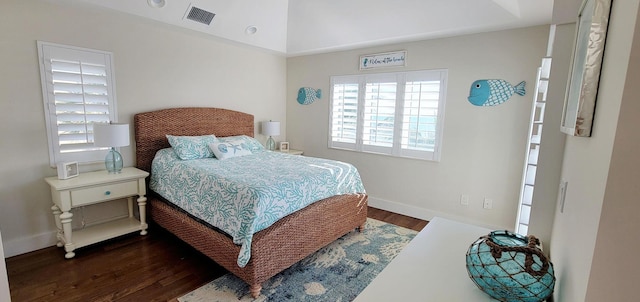 bedroom featuring visible vents, baseboards, and wood finished floors