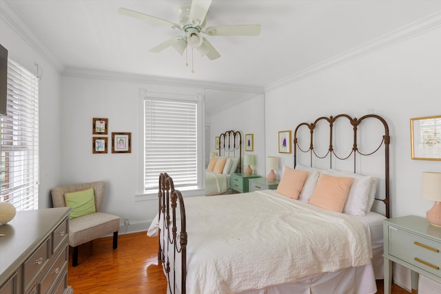 bedroom with ceiling fan, crown molding, baseboards, and wood finished floors