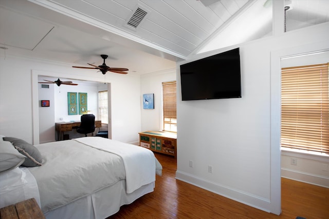 bedroom featuring visible vents, attic access, vaulted ceiling, wood finished floors, and baseboards