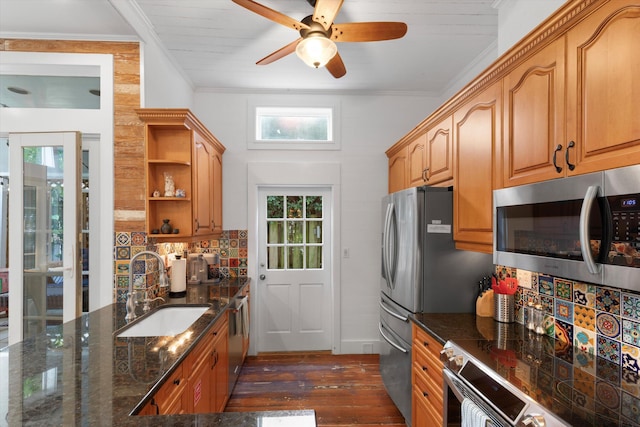 kitchen featuring crown molding, open shelves, appliances with stainless steel finishes, a sink, and dark stone countertops