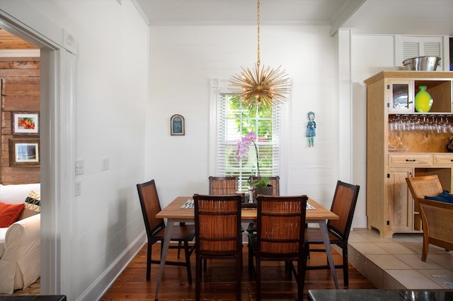 dining area featuring an inviting chandelier, baseboards, ornamental molding, and wood finished floors