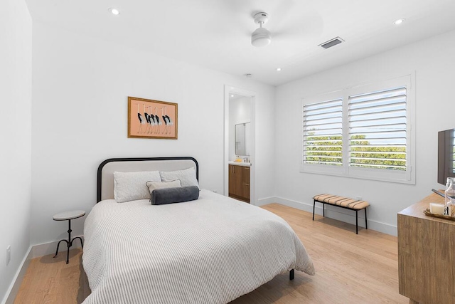 bedroom with ceiling fan, connected bathroom, and light wood-type flooring