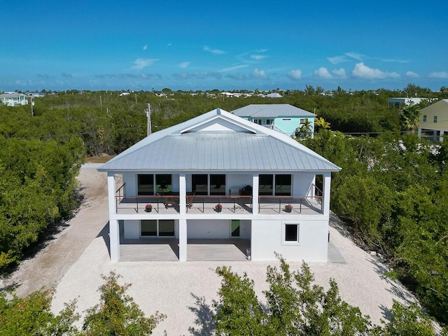 rear view of house featuring a balcony and a patio area