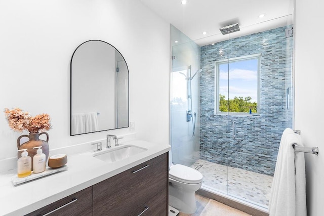 bathroom featuring vanity, an enclosed shower, and toilet