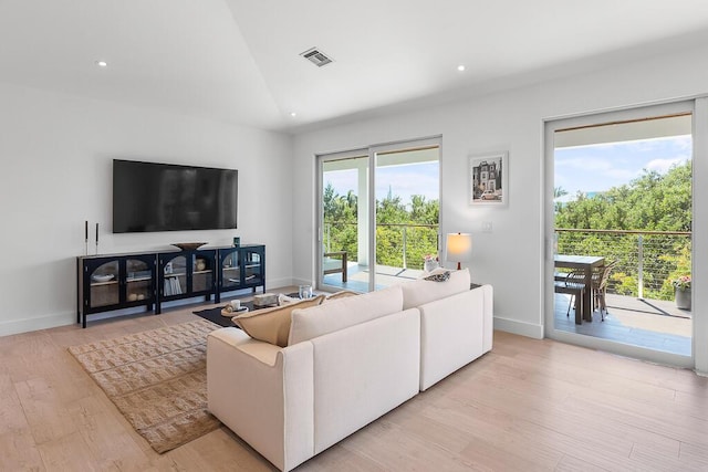 living room with vaulted ceiling and light wood-type flooring