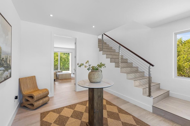 stairs with hardwood / wood-style flooring and radiator heating unit