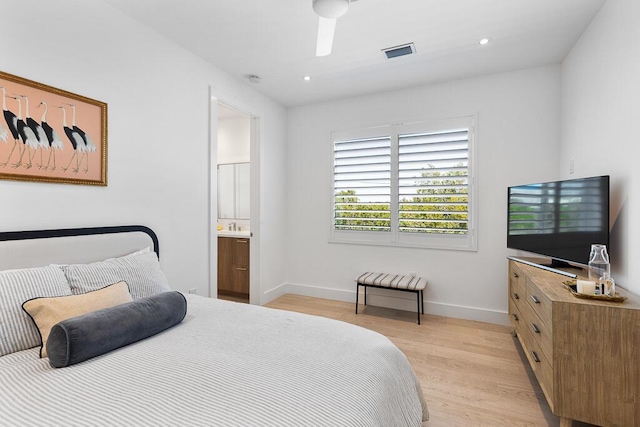 bedroom with ensuite bath and light hardwood / wood-style floors