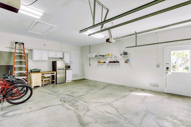 garage featuring a garage door opener and stainless steel fridge