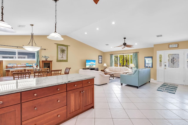 kitchen featuring light tile patterned flooring, light stone counters, decorative light fixtures, vaulted ceiling, and ceiling fan