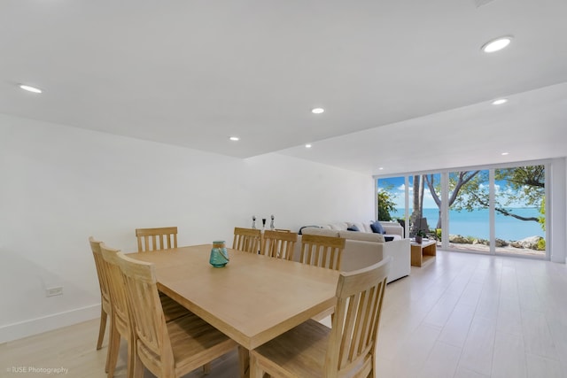 dining space with light hardwood / wood-style floors and a wall of windows