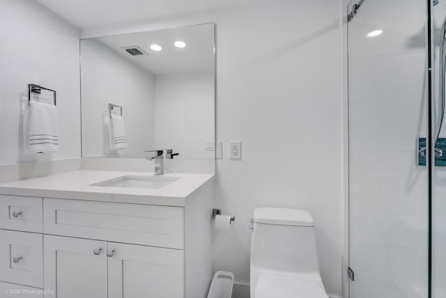 bathroom featuring vanity, walk in shower, and toilet