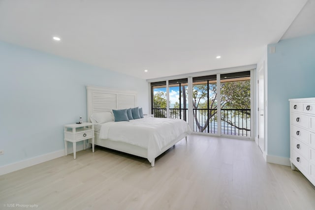 bedroom featuring expansive windows, access to outside, and light hardwood / wood-style flooring