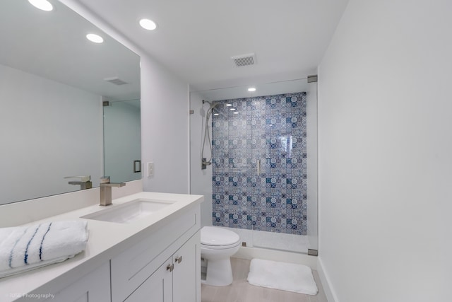 bathroom with an enclosed shower, vanity, and toilet