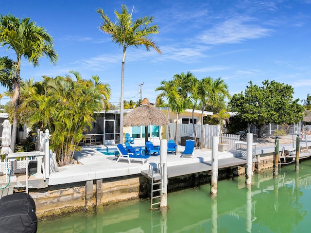dock area featuring fence, a water view, and a patio area