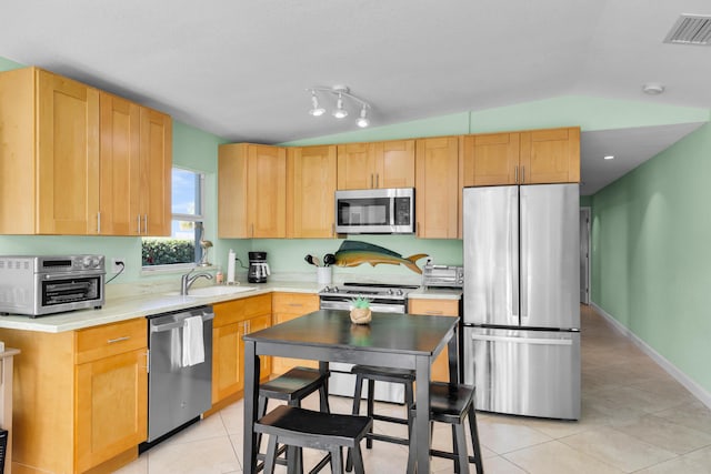 kitchen with light tile patterned flooring, appliances with stainless steel finishes, a sink, a toaster, and visible vents