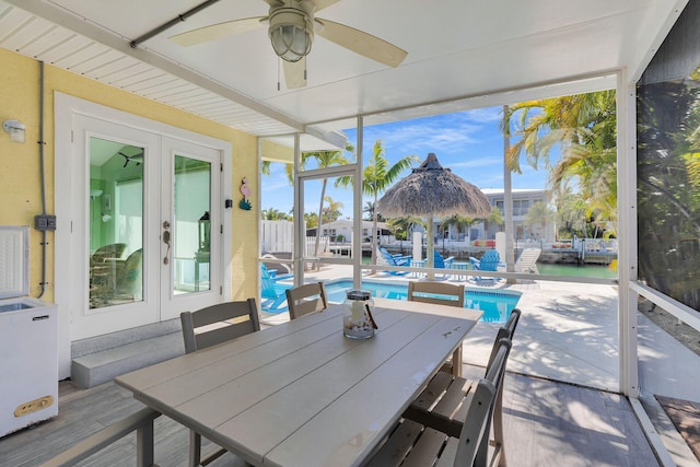 sunroom featuring a water view and french doors