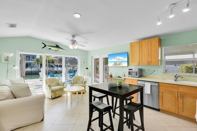 kitchen with stainless steel dishwasher, visible vents, ceiling fan, a sink, and light tile patterned floors