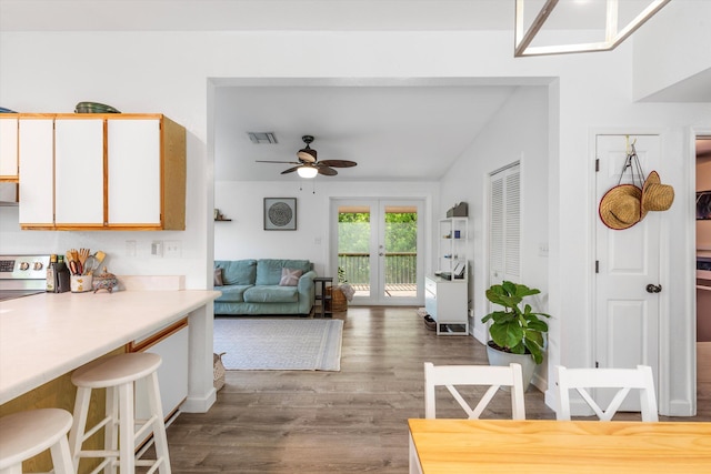 interior space featuring white cabinetry, stainless steel range with electric stovetop, ceiling fan, dark wood-type flooring, and french doors