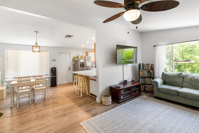 living room with ceiling fan and light wood-type flooring