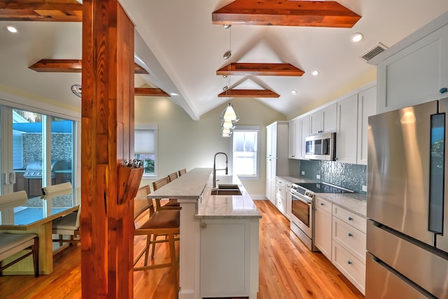 kitchen with visible vents, a healthy amount of sunlight, light wood-type flooring, a sink, and appliances with stainless steel finishes