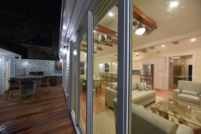 doorway to outside with recessed lighting, vaulted ceiling with beams, and wood finished floors