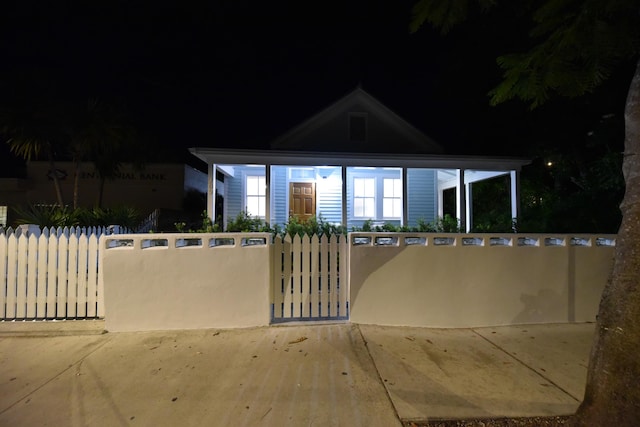 view of front of home with a fenced front yard and a gate