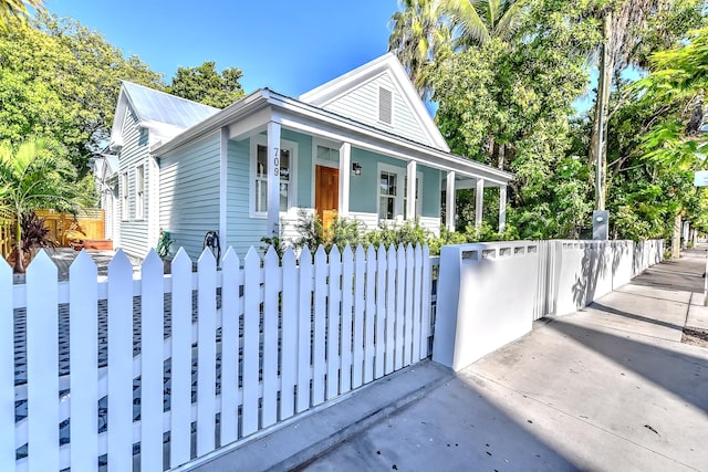 bungalow-style home with a porch, a fenced front yard, and a gate