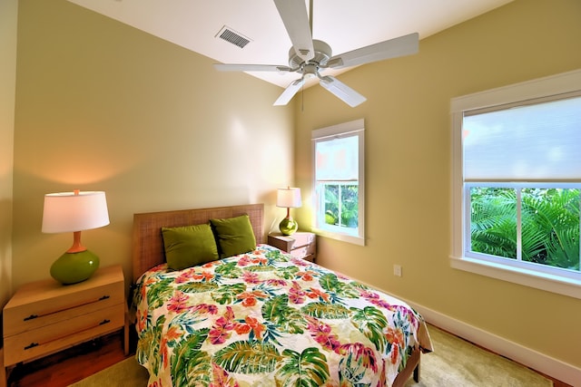 bedroom featuring baseboards, multiple windows, a ceiling fan, and visible vents