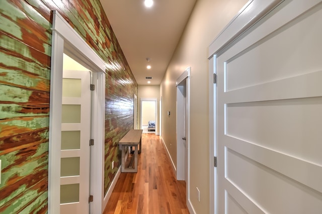 hallway with light wood-style floors, baseboards, recessed lighting, and visible vents