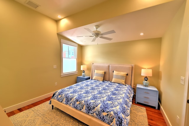 bedroom featuring visible vents, a ceiling fan, baseboards, and wood finished floors