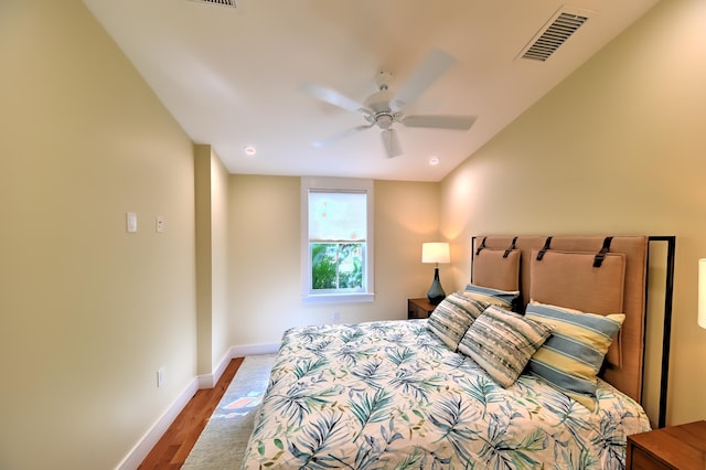 bedroom with baseboards, ceiling fan, wood finished floors, and visible vents