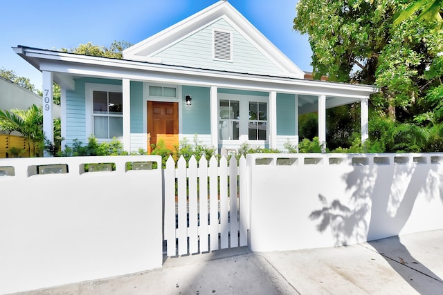 view of front of property with a fenced front yard and a porch