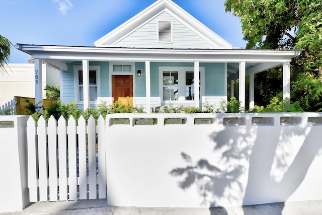 view of front of house featuring a gate, a fenced front yard, and covered porch
