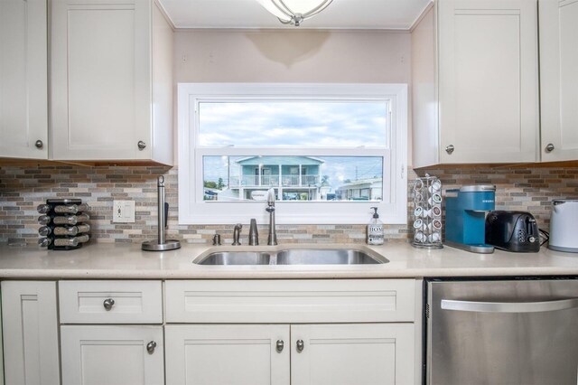 kitchen featuring tasteful backsplash, sink, white cabinets, and dishwasher