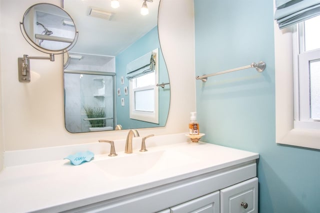 bathroom with a shower with door and vanity