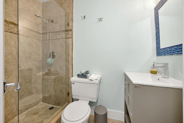 bathroom with vanity, toilet, and a tile shower