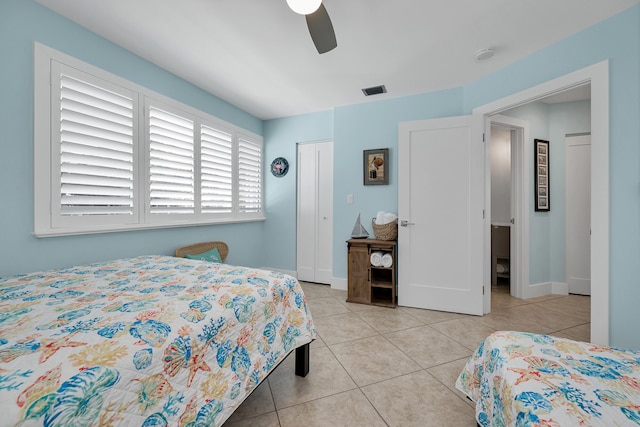 bedroom with light tile patterned flooring, ceiling fan, and a closet