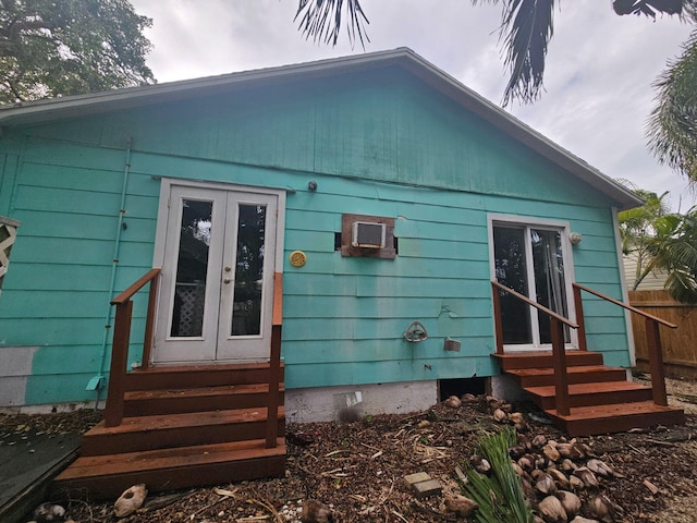 rear view of house with entry steps, french doors, fence, and crawl space