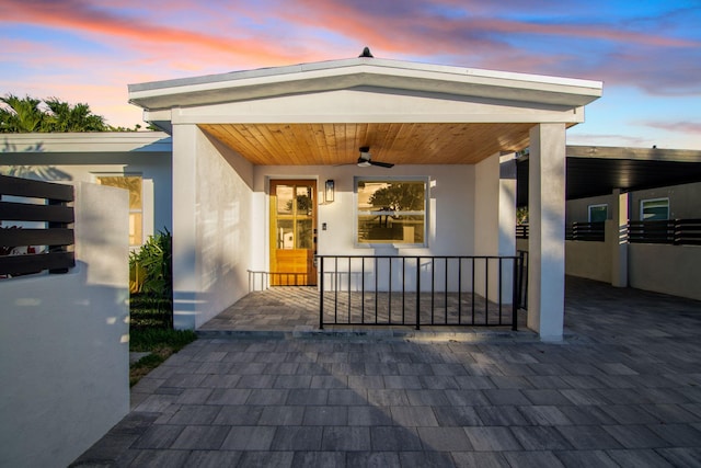 exterior entry at dusk with a porch and stucco siding