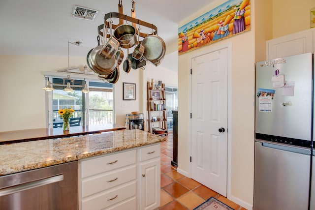 kitchen featuring light tile patterned floors, stainless steel appliances, visible vents, and white cabinetry