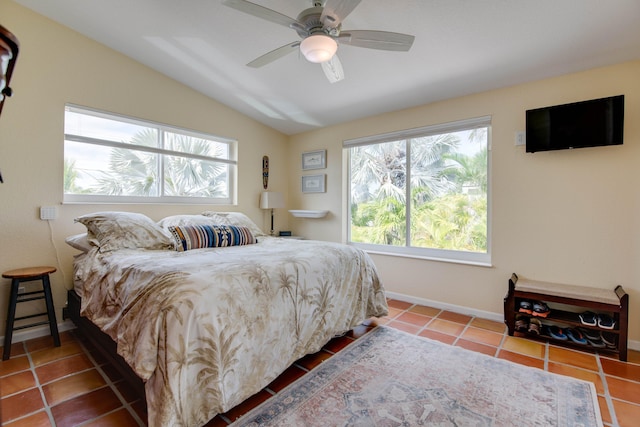 bedroom with vaulted ceiling, ceiling fan, tile patterned flooring, and baseboards