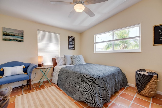 bedroom with a ceiling fan, vaulted ceiling, baseboards, and tile patterned floors