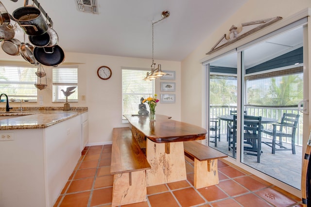 dining area featuring a wealth of natural light, visible vents, and light tile patterned flooring