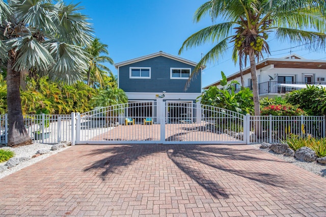 exterior space featuring a gate, fence, and decorative driveway