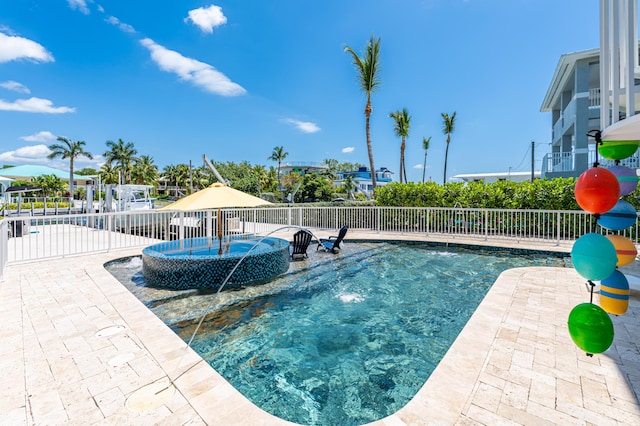 view of swimming pool featuring pool water feature and a patio