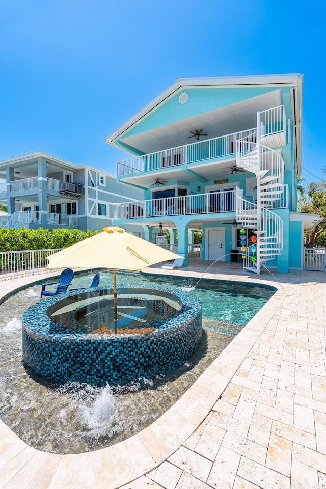 exterior space featuring an in ground hot tub, pool water feature, ceiling fan, and a patio area